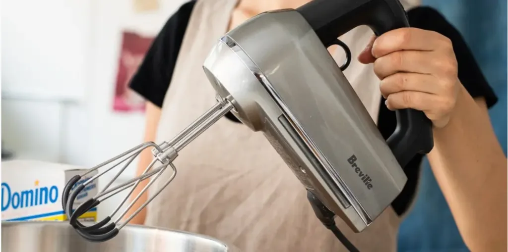 How Does a Hand Mixer Simplify Baking Tasks? 1 a person holding a mixer